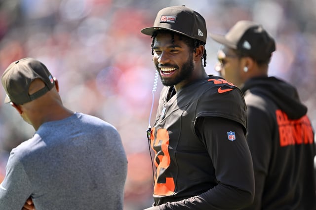 Quarterback Shedeur Sanders #12 of the Cleveland Browns talks to a teammate on the sidelines during the first half against the Green Bay Packers at Huntington Bank Field on September 21, 2025 in Cleveland, Ohio.
