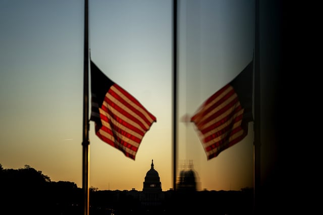 The Capitol is seen past an American flag flying at half staff in Washington, D.C. on Oct. 19, 2021.