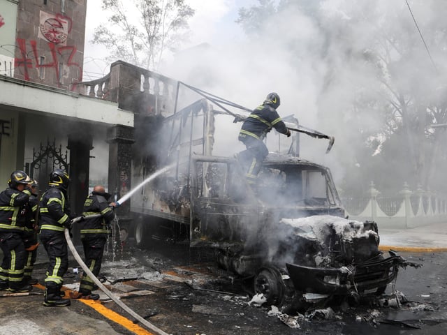 Firefighters work to extinguish a fire in a truck that was rammed into a gate and set on fire by students from the Raul Isidro Burgos Rural Teachers' College of Ayotzinapa, following a protest outside Campo Militar No. 1, ahead of the 11th anniversary of the disappearance of 43 students, in Mexico City, Mexico, September 25, 2025. REUTERS/Paola Garcia