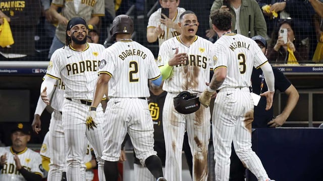 Oct 8, 2024; San Diego, California, USA; San Diego Padres second baseman Xander Bogaerts (2) and outfielder Jackson Merrill (3) celebrate with outfielder Fernando Tatis Jr. (23), left, and third baseman Manny Machado (13) after scoring in the second inning against the Los Angeles Dodgers during game three of the NLDS for the 2024 MLB Playoffs at Petco Park. Mandatory Credit: David Frerker-Imagn Images
