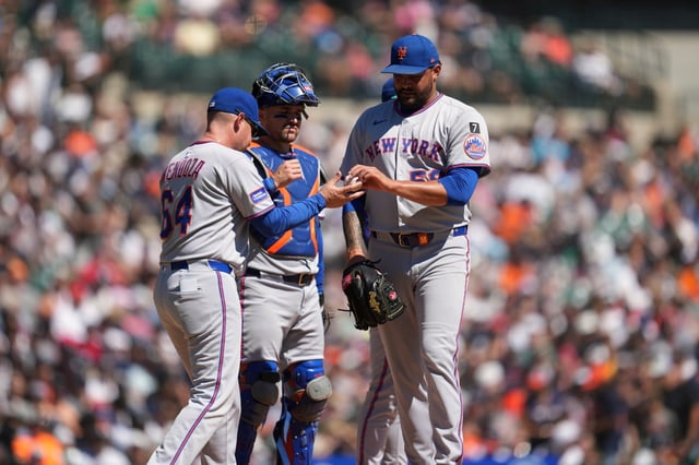 New York Mets manager Carlos Mendoza (64) takes the ball from pitcher Sean Manaea (59) against the Detroit Tigers in the fifth inning during a baseball game Monday, Sept. 1, 2025, in Detroit. (AP Photo/Paul Sancya)