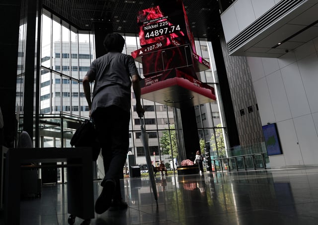 A man looks at a screen showing the Nikkei share average inside a financial building in Tokyo, Japan, September 18, 2025. REUTERS/Kim Kyung-Hoon/File Photo
