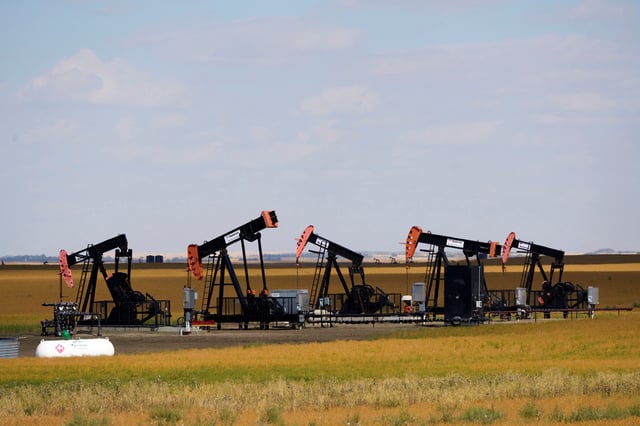 Oil pumpjacks and tanks are pictured in a farmer’s field near Kindersley, Saskatchewan, Canada September 5, 2024.  REUTERS/Todd Korol/File Photo
