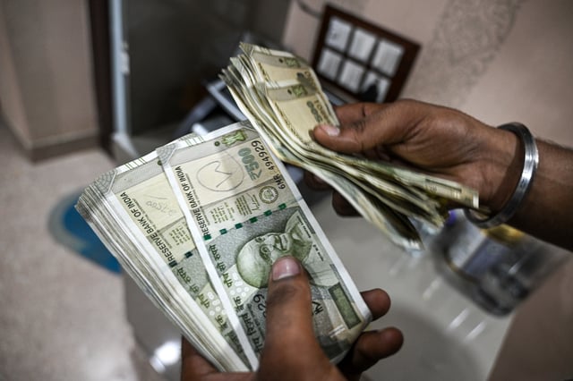 An employee counts 500 rupee banknotes at a currency exchange in New Delhi, India, on Saturday, Aug. 30, 2025. The Indian rupee slumped to a record low versus the dollar on concern that 50% US tariffs will hurt the country’s economic growth and corporate earnings. Photographer: Prakash Singh/Bloomberg