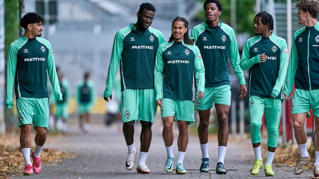 Werders Fußballer um Victor Boniface, Isaac Schmidt, Cameron Puertas und Samuel Mbangula schlendern locker zum Trainingsplatz.