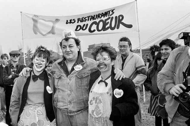 Coluche devant l’entrée de l’un des trois Restaurants du cœur de région parisienne, en décembre 1985.