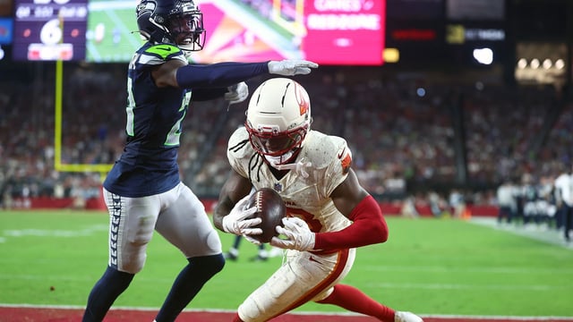 Sep 25, 2025; Glendale, Arizona, USA; Arizona Cardinals wide receiver Marvin Harrison Jr. (18) makes a catch for a touchdown against Seattle Seahawks cornerback Devon Witherspoon (21) in the fourth quarter at State Farm Stadium. Mandatory Credit: Mark J. Rebilas-Imagn Images
