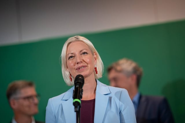 Clara Gerlach steht an einem Mikrofon und spricht