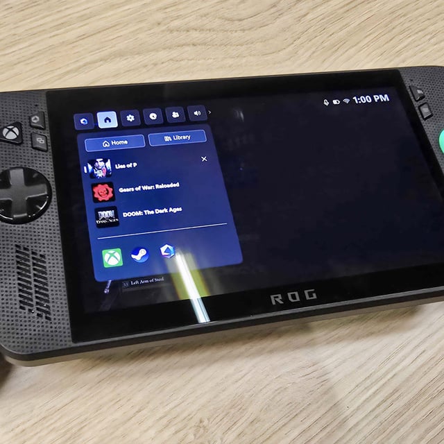 ROG Xbox Ally X on a wooden table with the side menu open. 
