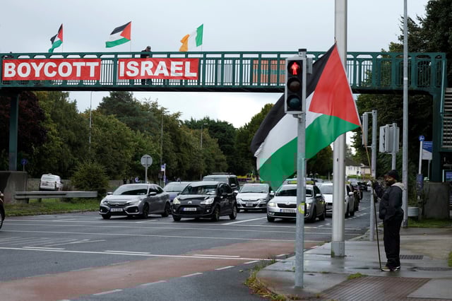 Pro-Palestinian protestors hold flags and a sign on a motorway overpass outside the RTE (Radio Telefis Eireann) Irish public service broadcaster television studios, in Dublin, Ireland, September 11, 2025. REUTERS/Clodagh Kilcoyne/File Photo