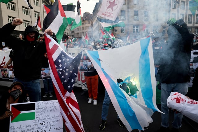 Pro-Palestinian demonstrators burn representations of the U.S. and Israeli flags during a protest, on the day of the Grand Final of the 2025 Eurovision Song Contest in Basel, Switzerland, May 17, 2025. REUTERS/Christian Hartmann/File Photo