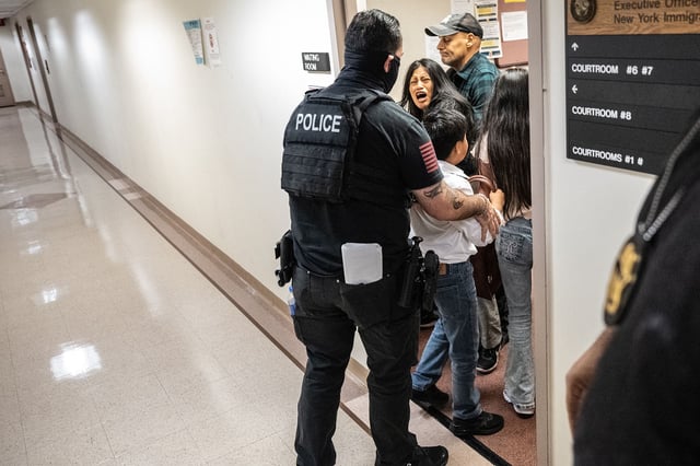 A federal agent restrains a woman on Thursday at an immigration courthouse in New York City.