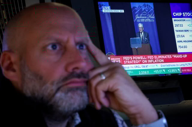 A specialist trader works on the floor at the New York Stock Exchange (NYSE), as a screen shows Federal Reserve Chairman Jerome Powell speaking during the Jackson Hole conference, in New York City, U.S., August 22, 2025.  REUTERS/Brendan McDermid/File Photo