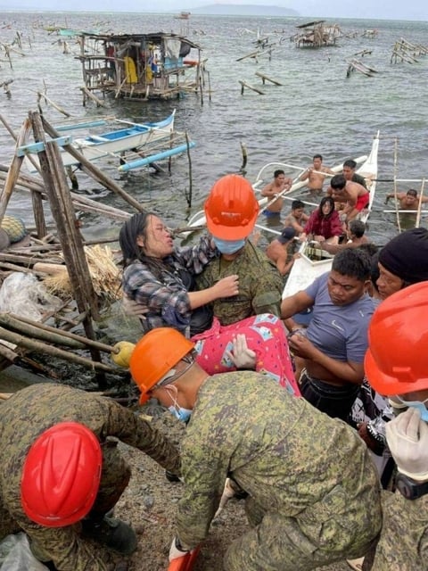 Photo de l'armée philippine montrant des soldats secourant des habitants le 25 septembre 2025 durant le passage de la tempête tropicale Bualoi à Guiuan