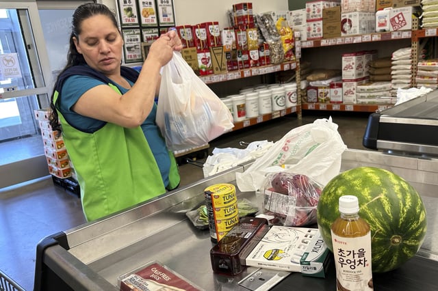 An employee works at a cash register in a grocery store in Schaumburg, Ill., Thursday, Sept. 18, 2025. (AP Photo/Nam Y. Huh)