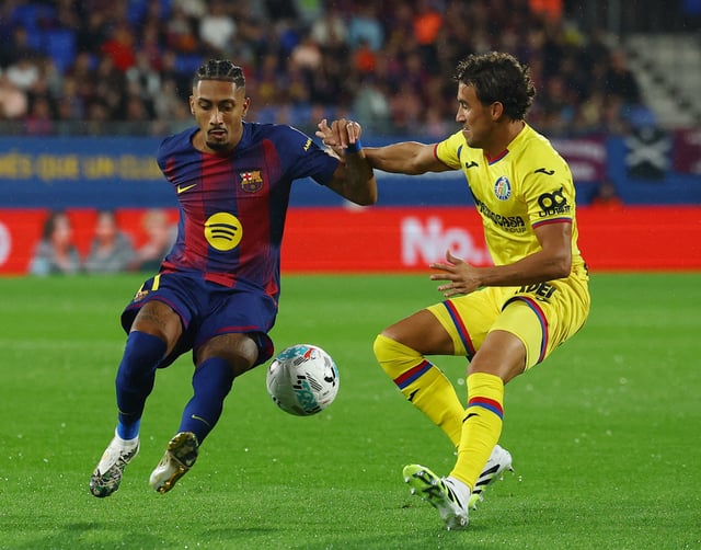 Soccer Football - LaLiga - FC Barcelona v Getafe - Johan Cruyff Stadium, Barcelona, Spain - September 21, 2025 FC Barcelona's Raphinha in action with Getafe's Luis Milla REUTERS/Albert Gea