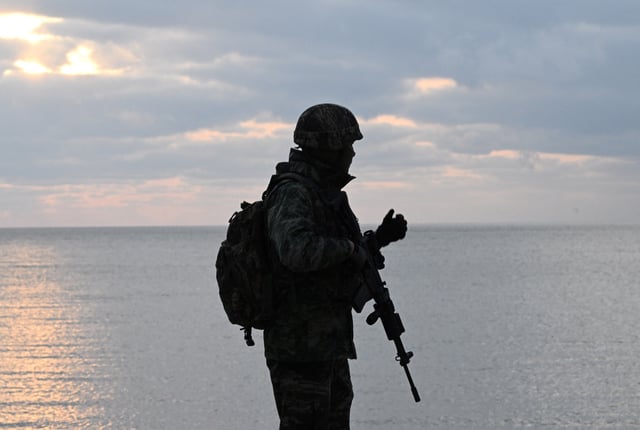A South Korean marine patrols a beach on Yeonpyeong island, near the 'northern limit line' sea boundary with North Korea on January 8, 2024. Since January 5, Pyongyang's military has fired hundreds of artillery shells near two sparsely-populated South Korean border islands, prompting evacuation orders, ferry cancelations and counter-drills. (Photo by Jung Yeon-je / AFP) (Photo by JUNG YEON-JE/AFP via Getty Images)