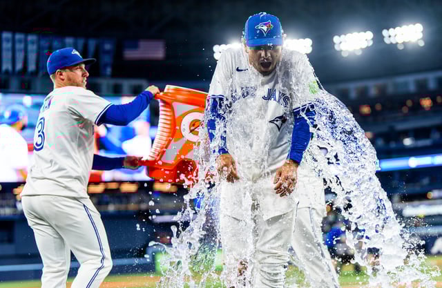 TORONTO, CANADA - AUGUST 25: Andres Gimenez #0 of the Toronto Blue Jays gets doused in water by teammates during a post-game interview following their team's win over the Minnesota Twins in the MLB game at the Rogers Centre on August 25, 2025 in Toronto, Canada. (Photo by Mark Blinch/Getty Images)