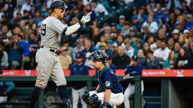 May 30, 2023; Seattle, Washington, USA; New York Yankees center fielder Aaron Judge (99) celebrates after hitting a solo-home run against the Seattle Mariners during the seventh inning at T-Mobile Park. Seattle Mariners catcher Cal Raleigh (29) kneels at right. Mandatory Credit: Joe Nicholson-Imagn Images