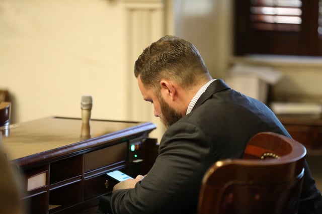 FILE - Republican South Carolina Rep. R.J. May of Lexington sits at his new desk during the organizational session for the House on Tuesday, Dec. 3, 2024, in Columbia, S.C. (AP Photo/Jeffrey Collins, file)
