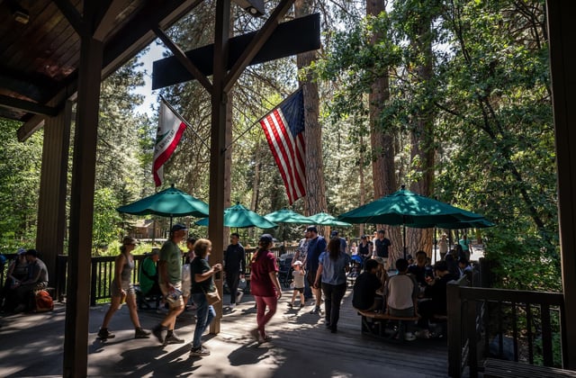 Visitors gather near the Valley Store in Yosemite National Park in May 2025. More than three dozen former park superintendents are urging President Trump to close Yosemite and all 433 national park sites if the government shuts down next week.