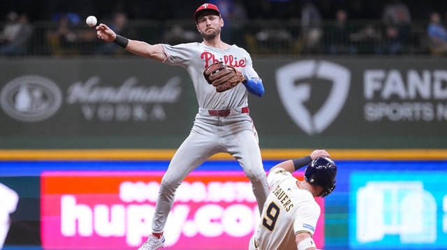 Sep 3, 2025; Milwaukee, Wisconsin, USA; Philadelphia Phillies shortstop Trea Turner (7) turns a double play as Milwaukee Brewers first baseman Jake Bauers (9) slides into second base during the sixth inning at American Family Field. Mandatory Credit: Jeff Hanisch-Imagn Images