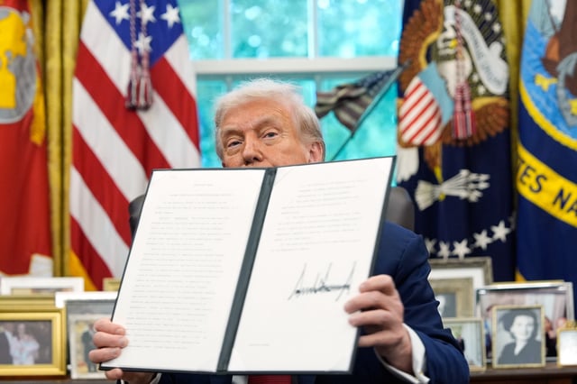 President Donald Trump holds a signed executive order regarding TikTok in the Oval Office at the White House, Thursday, Sept. 25, 2025, in Washington. (AP Photo/Alex Brandon)