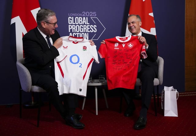 Prime Minister Mark Carney and British Prime Minister Keir Starmer exchange the jerseys of their national women's rugby teams as they meet to take part in a bilateral meeting with the Global Progress Action Summit in London on Friday, Sept. 26, 2025. THE CANADIAN PRESS/Sean Kilpatrick