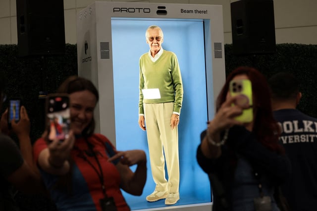 Attendees take selfies in front of an AI hologram of comic book writer Stan Lee projected into a Proto Epic device during L.A. Comic Con in Los Angeles, California, U.S., September 26, 2025. REUTERS/Mario Anzuoni