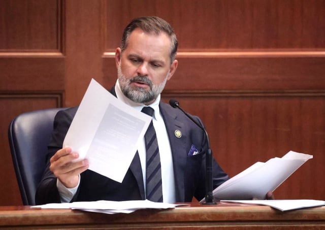 U.S. Rep. Cory Mills looks at evidence transcripts and  photos during cross examination by attorney Bobi Frank at a hearing in Third Judicial Circuit court in Lake City, Fla., Friday, Sept. 26, 2025. Frank represents Mills' ex-girlfriend Lindsey Langston, a state GOP committeewoman and the reigning Miss United States, who is seeking a restraining order against him. (Joe Burbank/Orlando Sentinel)