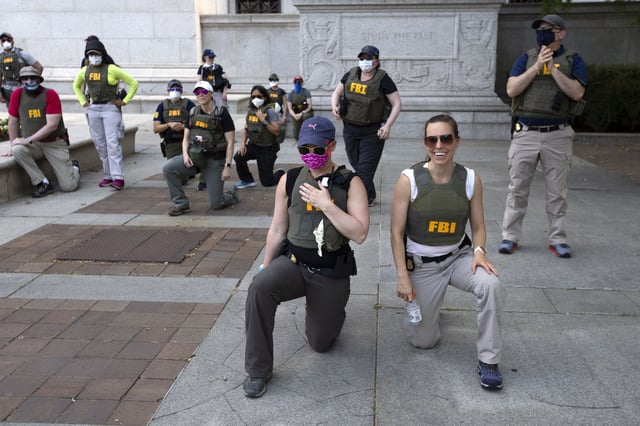 Federal Bureau of Investigation (officers take a knee with demonstrators, as they march on Pennsylvania Ave. on Thursday, June 4, 2020, in Washington, during a protest over the death of George Floyd, an unarmed black man who died after a police officer kneeled on his neck for several minutes.