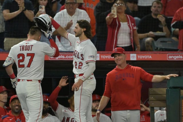 Angels interim manager Ray Montgomery, right, looks on as Angels star Mike Trout, left, is congratulated by teammate Bryce Teodosio as he returns to the dugout after hitting a solo home run during the fourth inning of their game against the Houston Astros on Friday night at Angel Stadium. Trout homered twice in the Angels’ 4-3 win. (AP Photo/Jayne Kamin-Oncea)