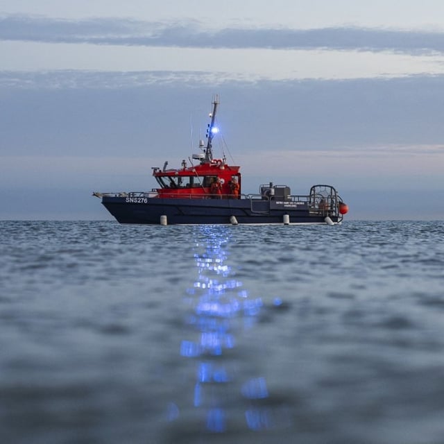 Un bateau de sauvetage à proximité de migrants tentant de traverser la Manche au large de la plage de Gravelines (Nord), le 19 septembre 2025