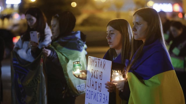 Varias personas, este viernes en Kiev durante un homenaje a los militares ucranianos fallecidos en la guerra.