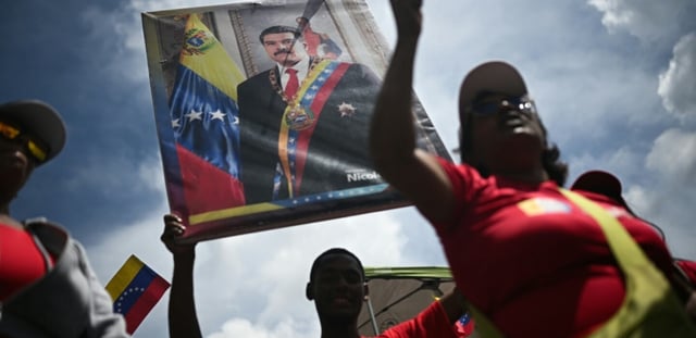 Un homme tient un portrait du président vénézuélien Nicolas Maduro, le 23 septembre 2025 à Caracas