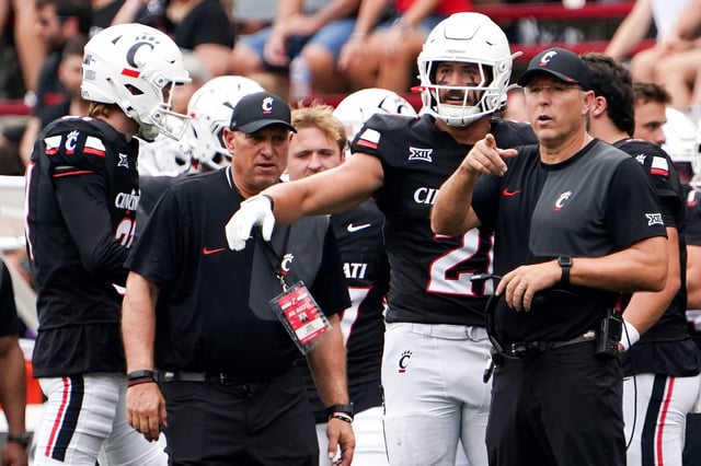 Cincinnati football coach Scott Satterfield speaks with players during a game against Northwestern State on Sept. 13, 2025, at Nippert Stadium in Cincinnati.