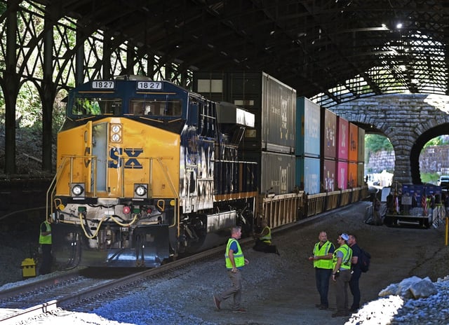A double-stacked freight train stands as backdrop for the ceremony to reopen the expanded Howard Street Tunnel marking a milestone toward modernizing freight rail capacity from the Port of Baltimore throughout the East Coast.  (Kenneth K. Lam/staff)