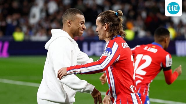 Real Madrid's Kylian Mbappe shakes hands with Atletico Madrid's Antoine Griezmann.