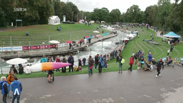 Zuschauer stehen an einem Flussufer