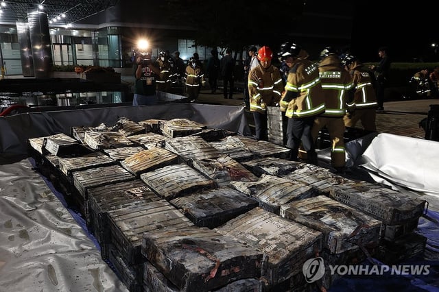 Firefighters submerge lithium-ion batteries in water while extinguishing a fire at the National Information Resources Service in Daejeon, some 160 kilometers southeast of Seoul, on Sept. 27, 2025. (Yonhap)