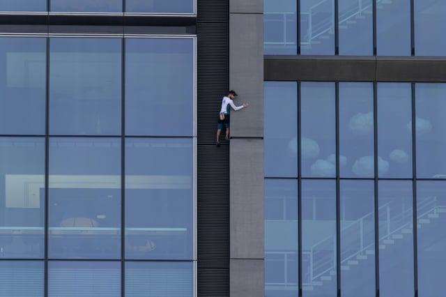 Le grimpeur français Titouan Leduc escalade à mains nues et sans protection la Varso Tower, le plus haut gratte-ciel de l'Union européenne, à Varsovie, le 27 septembre 2025 en Pologne