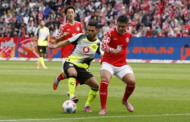Soccer Football - Bundesliga - 1. FSV Mainz 05 v Borussia Dortmund - MEWA Arena, Mainz, Germany - September 27, 2025 Borussia Dortmund's Yan Couto in action with 1. FSV Mainz 05's Nadiem Amiri REUTERS/Heiko Becker