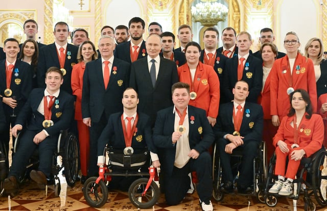 In this pool photograph distributed by the Russian state agency Sputnik, Russia's President Vladimir Putin poses for pictures with Russian Paralympians, medallists from the Paris 2024 Paralympic Games following a state awards ceremony at the Kremlin in Moscow on December 16, 2024.