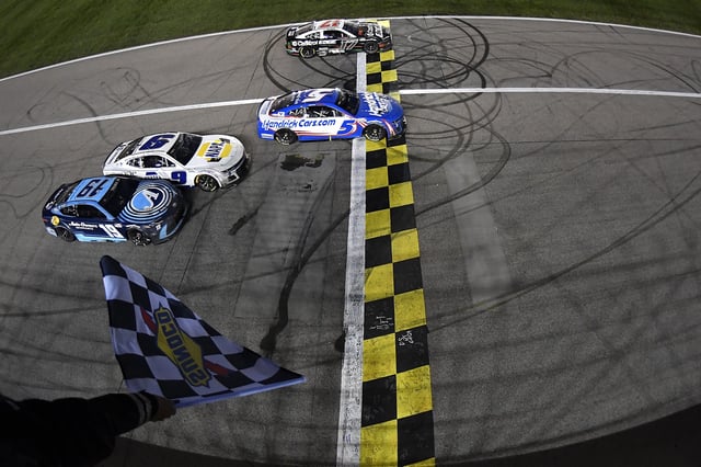 Kyle Larson, driver of the #5 HendrickCars.com Chevrolet, takes the checkered flag over Chris Buescher, driver of the #17 Castrol Edge Ford, to win the NASCAR Cup Series AdventHealth 400 at Kansas Speedway on May 05, 2024 in Kansas City, Kansas.