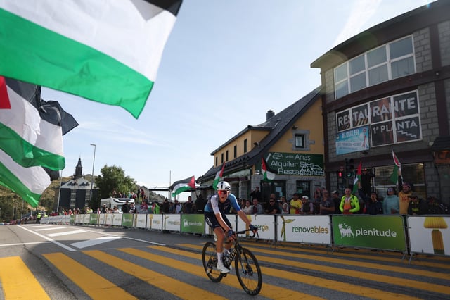 Cycling - Vuelta a Espana - Stage 20 - Robledo de Chavela to Bola del Mundo - Robledo de Chavela, Spain - September 13, 2025 Israel - Premier Tech's Marco Frigo in action as protestors wave Palestine flags/File Photo REUTERS/Bruna Casas