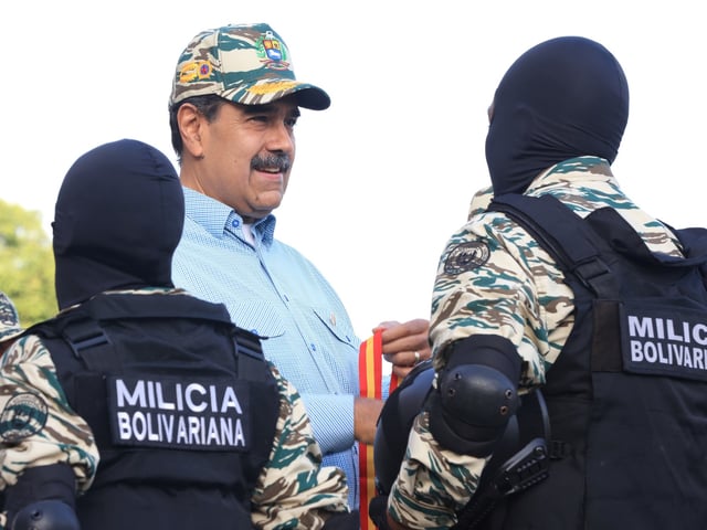 AME2567. CARACAS (VENEZUELA), 21/08/2025.- Fotografía cedida por prensa del Palacio de Miraflores del presidente de Venezuela, Nicolás Maduro (c), saludando a miembros de la Milicia Bolivariana este jueves, en Caracas (Venezuela). Maduro convocó a una jornada de alistamiento de las "fuerzas milicianas" durante el fin de semana, en respuesta al patrullaje de buques que planteó Estados Unidos en el mar Caribe, cerca del país suramericano, para combatir el narcotráfico. EFE/ Palacio de Miraflores /SOLO USO EDITORIAL/ NO VENTAS/ SOLO DISPONIBLE PARA ILUSTRAR LA NOTICIA QUE ACOMPAÑA (CRÉDITO OBLIGATORIO)