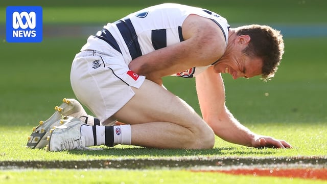 Jeremy Cameron crouched and nursing an arm injury during the Cats' AFL grand final against the Lions.