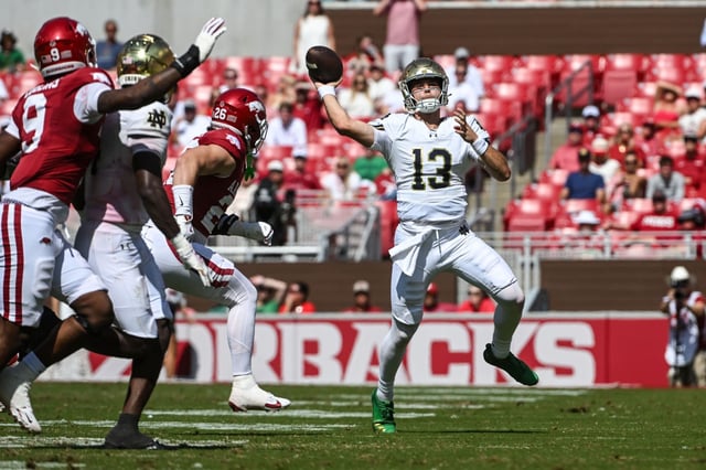 Notre Dame quarterback CJ Carr (13) throws a pass as he scrambles away from Arkansas defenders during the second half Saturday, Sept. 27, 2025, in Fayetteville, Ark. (Michael Woods/AP)