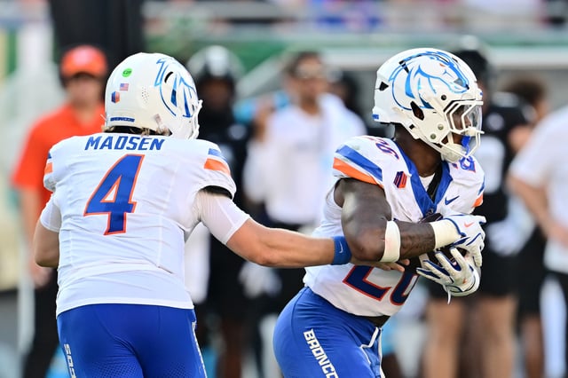 Maddux Madsen #4 hands the ball off to Sire Gaines #26 of the Boise State Broncos in the first half against the South Florida Bulls at Raymond James Stadium on August 28, 2025 in Tampa, Florida.