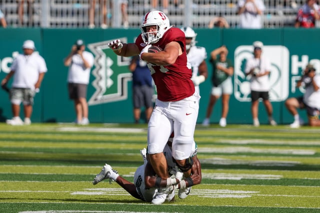 Chico Holt #84 of the Stanford Cardinal is tackled by Jaheim Wilson-Jones #14 of the Hawaii Rainbow Warriors during the second half at the Clarence T.C. Ching Athletics Complex on August 23, 2025 in Honolulu, Hawaii.